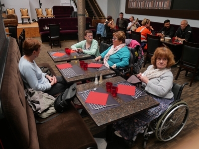 Photo montrant des personnes en situation de handicap attablées dans la salle de restaurant